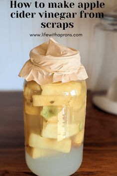 a mason jar filled with sliced apples and cider vinegar from scraps on a wooden table