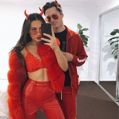 a man and woman in red outfits taking a selfie