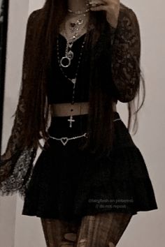 a woman with long hair wearing a black outfit and holding a cell phone to her ear