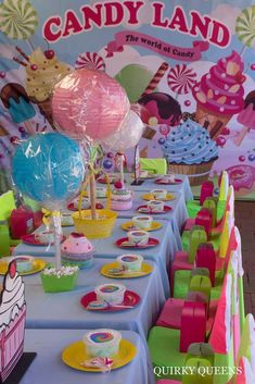 a table topped with lots of cupcakes and balloons