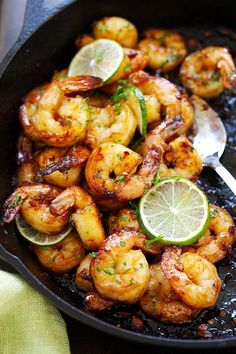 a skillet filled with shrimp and lime slices