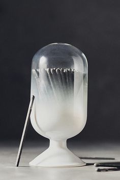 a glass vase sitting on top of a table next to a black and white object