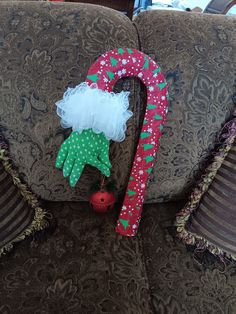 a christmas decoration on the back of a couch with a candy cane attached to it