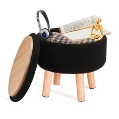 a small stool with a book and headphones on it's legs in front of a white background