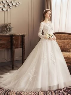 a woman in a wedding dress standing next to a chair