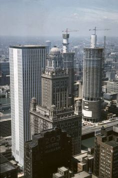 an aerial view of skyscrapers in the city with construction cranes on top and below