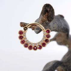 a close up of a pair of earrings with red stones on the inside of it