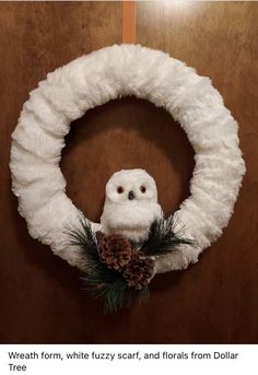 an owl sitting on top of a white wreath