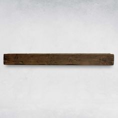 a piece of wood sitting on top of a white wall