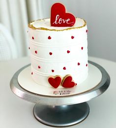 a white cake with red hearts on it