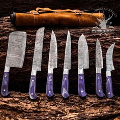 six knives are lined up in front of a knife sharpener and an old leather case