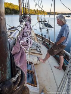 an older man standing on the deck of a sailboat