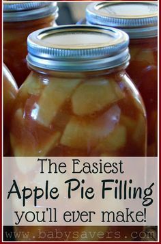 jars filled with pickled apples sitting on top of a table next to each other