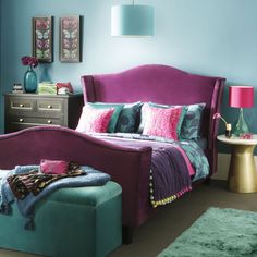 a bedroom with blue walls and purple furniture