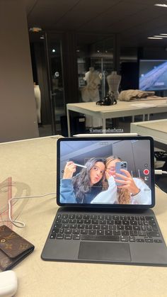 an open laptop computer sitting on top of a table next to a mouse and cell phone