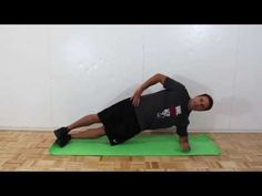 a man in black shirt doing yoga on green mat