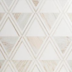 a white and beige tiled wall with diamond shapes on it's sides, as well as lines in the middle