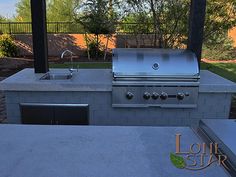 an outdoor kitchen with grill and sink