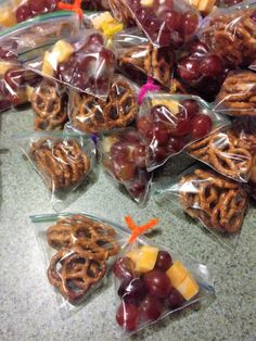 grapes, apples and pretzels are wrapped in cellophane to be used as snacks