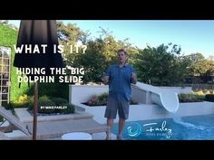 a man standing in front of a swimming pool with an umbrella over it and the words, what is hiding the big dolphin slide?