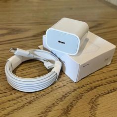 an apple charger sitting on top of a wooden table next to a white box