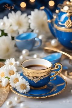 a blue tea cup and saucer on a table with white flowers in the background