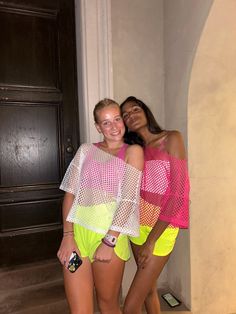 two women standing next to each other in front of a door wearing neon colored swimsuits