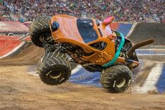 an orange monster truck is in the air