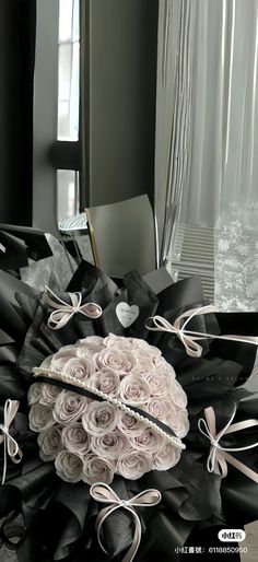 a bouquet of roses sitting on top of a pile of black and white cloths