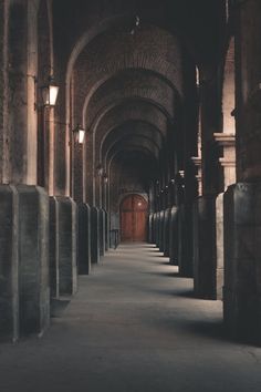 an empty hallway with several urinals lined up along the wall