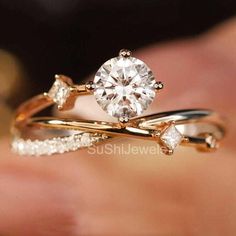 a close up view of a person's hand holding a ring with a diamond on it