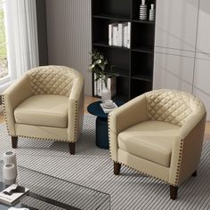 two beige chairs sitting next to each other on top of a rug