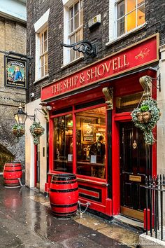 the ship and shovel restaurant on a rainy day in london, england with red barrels outside