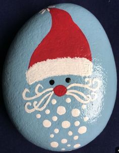 a painted rock with a santa hat on it