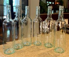 six empty glass bottles sitting on top of a counter