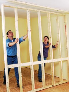 two people standing in a room that is being built