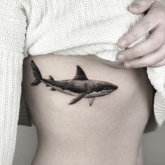 a woman's stomach with a shark tattoo on it