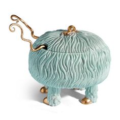 a blue ceramic box with gold handles and an octopus like decoration on the lid, sitting on its legs