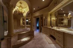 a large bathroom with two sinks, tub and chandelier in the middle of it