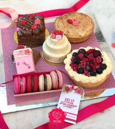 a table topped with lots of different types of cakes