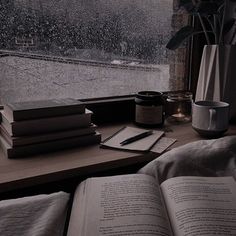 an open book sitting on top of a table next to a window