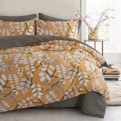 an orange and grey bed with white flowers on it