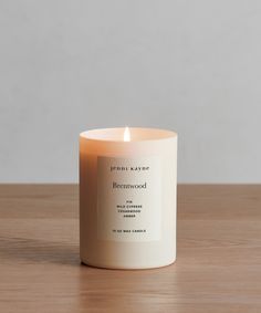 a white candle sitting on top of a wooden table