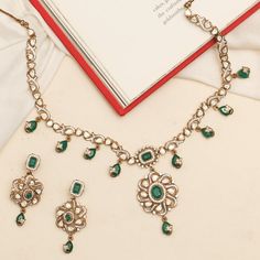 Description: Discover the Maya necklace set, a stunning blend of tradition and modern elegance. Showcasing a moissanite-studded central pendant with a floral design, highlighting an emerald green stone. Adorned with intricate motifs and drop emerald green stones, this necklace adds timeless brilliance and cultural charm to your jewelry collection. Product Information: Metal: 925 Silver with Victorian Plating Length: Necklace- 18cm, Earrings- 5cm Stones: High Grade CZ Stones Findings: Hook & Link Green Gemstone Diamond Necklace For Wedding, Traditional Emerald Necklace With Diamonds, Green Diamond Necklace With Gemstones For Wedding, Traditional Emerald Necklace With Intricate Design For Formal Occasions, Traditional Formal Emerald Necklace, Traditional Emerald Necklace With Diamond And Intricate Design, Elegant Silver Kundan Necklace With Emerald, Exquisite Green Gemstone Bridal Necklace, Elegant Emerald Kundan Necklace For Gift