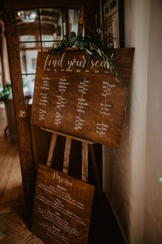 a wooden sign that says find your seat on the side of a building with greenery