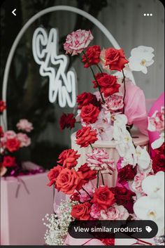 a pink and red wedding cake with flowers on it