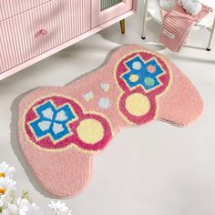 a pink bathroom rug with an elephant design on the floor next to a white chair