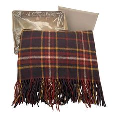 a plaid blanket with tassels on it and an empty bag next to it