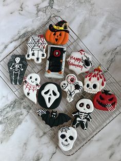 halloween decorated cookies sitting on top of a cooling rack