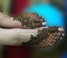 two feet covered in henna with roses on the top and bottom of their legs